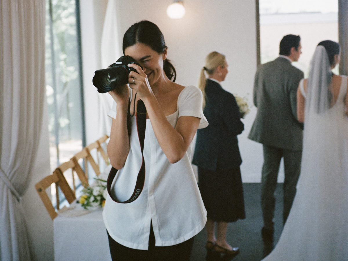 A photographer shooting while her assistant books the sessions
